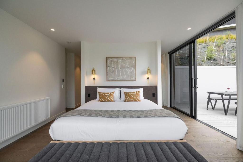 sypialnia z dużym białym łóżkiem i balkonem w obiekcie The Bunkers Penthouse-1 Bed w mieście Queenstown