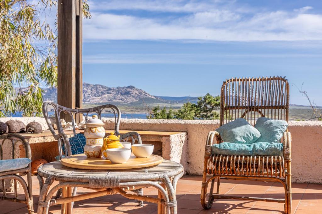 a table and chairs on a patio with a view of the ocean at Stintino villa with view over Asinara Island in Stintino