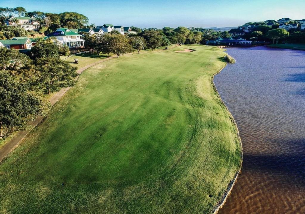 an aerial view of a golf course next to the water at Cosy Urban Apartment in Durban