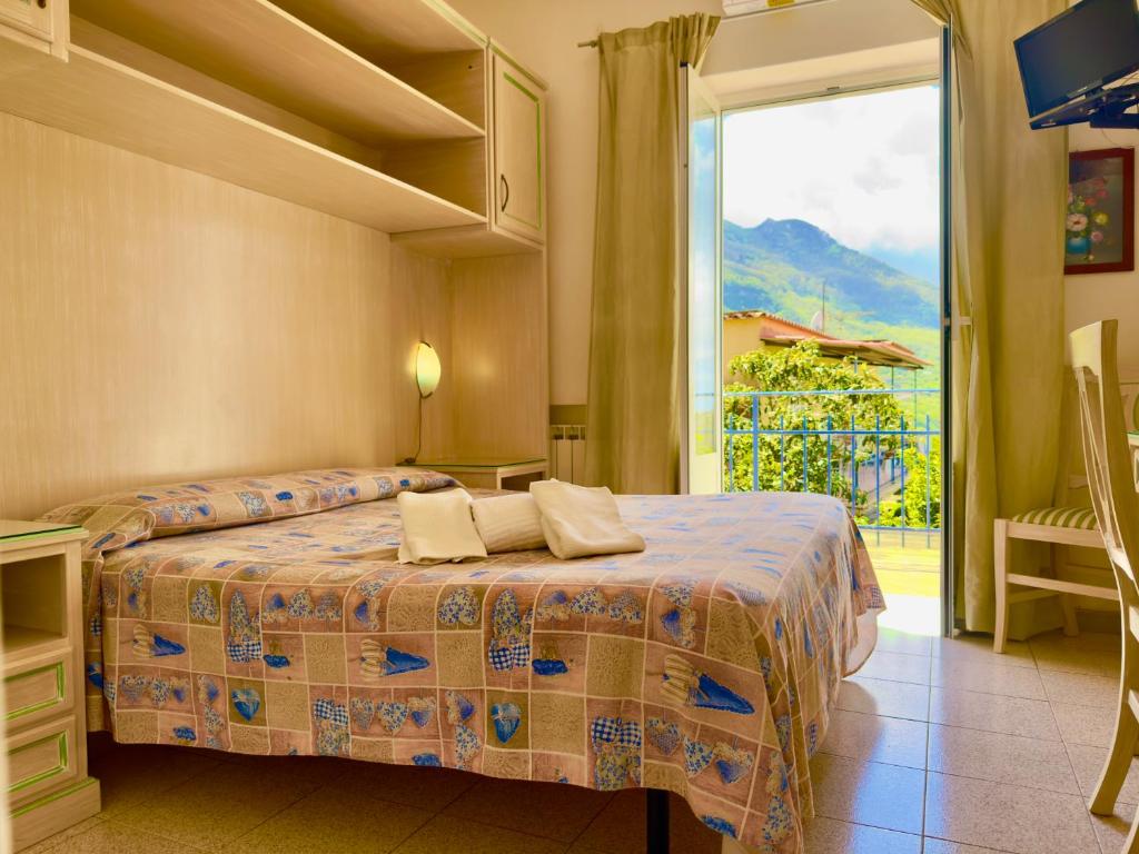 a bedroom with a bed and a large window at Hotel Villa Fiorentina in Ischia