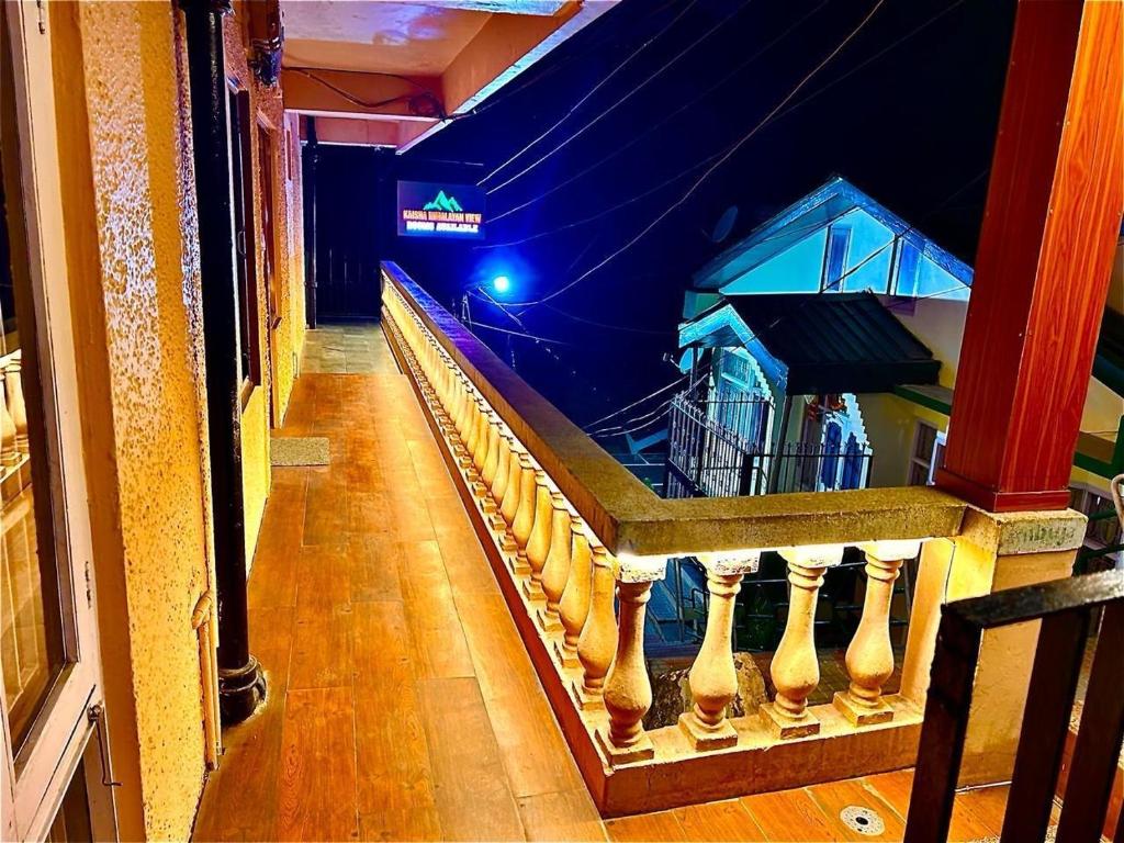 Kaisha Himalayan View في شيملا: اطلالة على شرفة مبنى في الليل