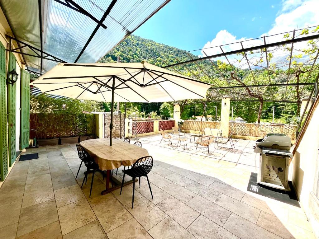 - une table avec un parasol sur la terrasse dans l'établissement Appartement terrasse vue lac, à Breil-sur-Roya