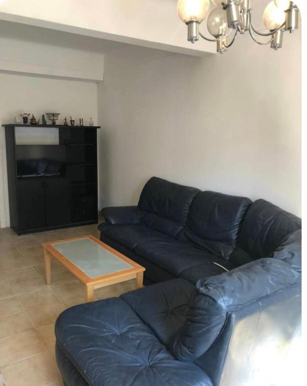 un salon avec un canapé bleu et une table basse dans l'établissement Grande maison de ville T7, à Perpignan