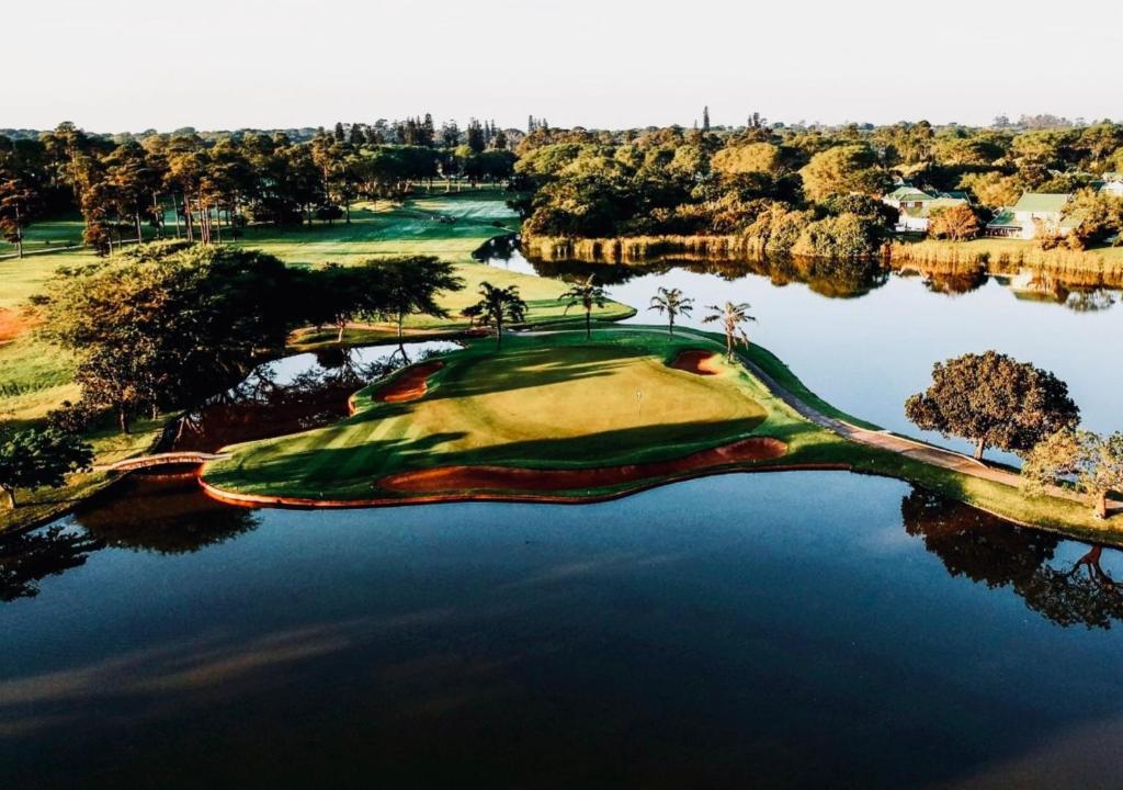 an aerial view of a golf course in the middle of a lake at Cosy Urban Apartment in Durban