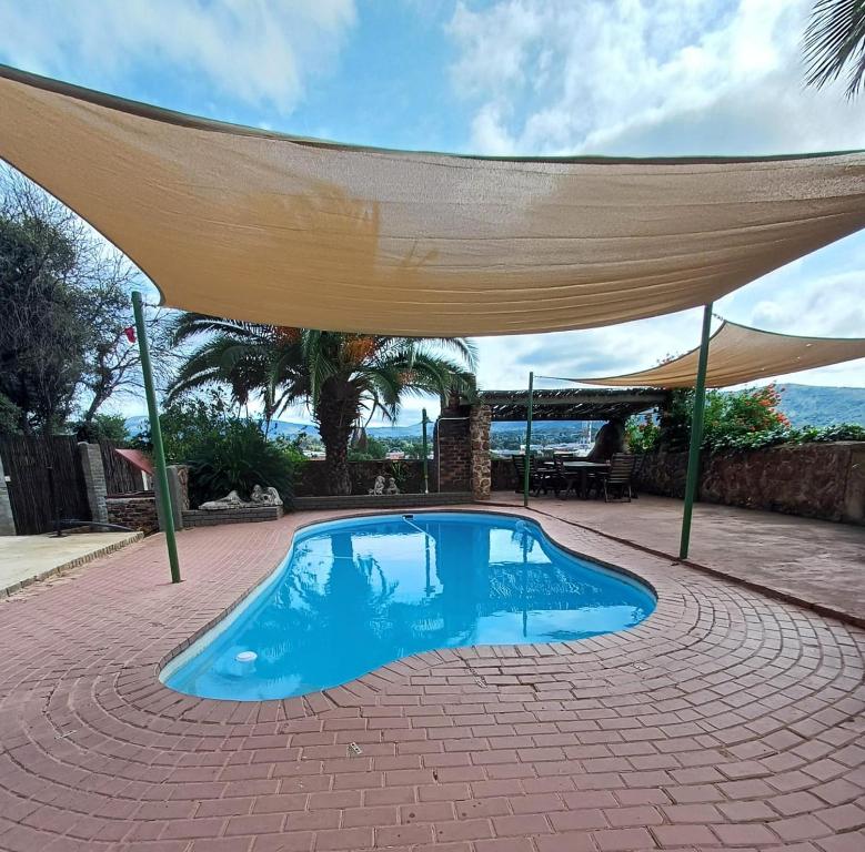 una piscina con baldacchino sopra di At Ease Road Lodge a Zeerust