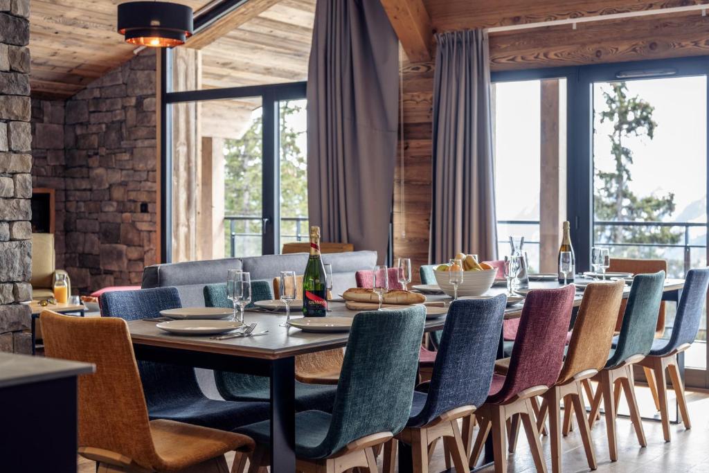 ein Esszimmer mit einem langen Tisch und Stühlen in der Unterkunft Madame Vacances Résidence L'Orée du Bois in La Rosière