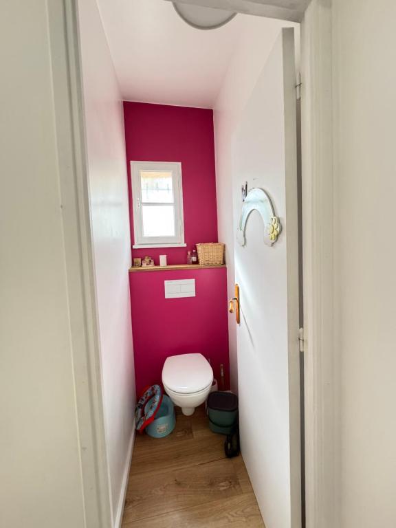 La salle de bains est pourvue de toilettes et d'un mur rose. dans l'établissement Cannes hills villa with garden and parking, au Cannet