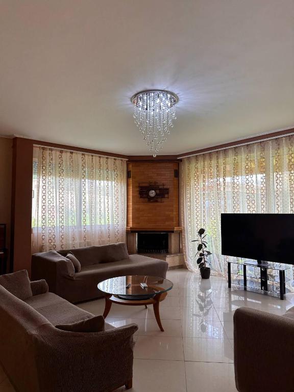 ein Wohnzimmer mit einer Couch und einem Kronleuchter in der Unterkunft La Maison in Áyios Nikólaos