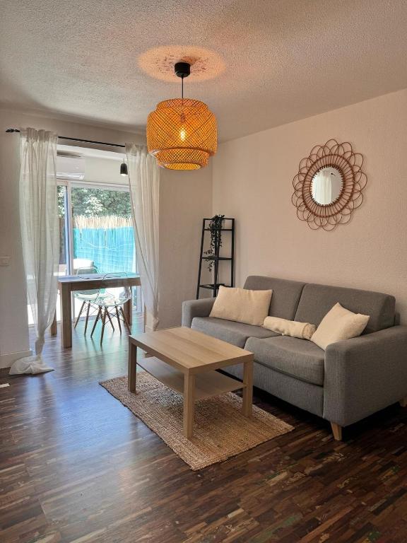 un salon avec un canapé et une table dans l'établissement Studio Terrasse à Sainte-Maxime Classé Meublé de Tourisme, à Sainte-Maxime