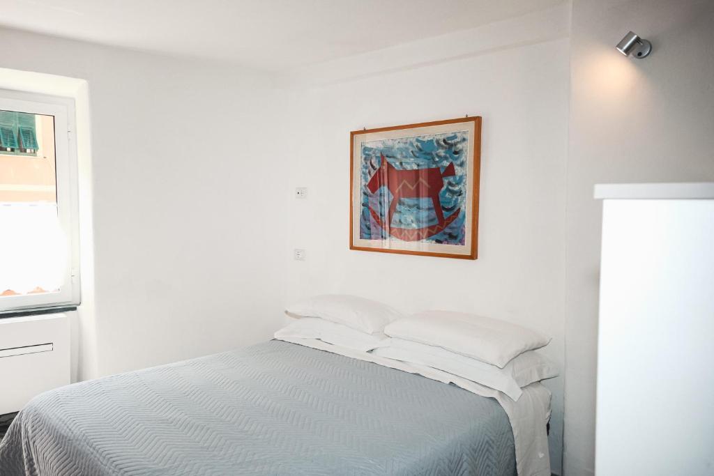 una camera bianca con un letto e una foto appesa al muro di Costellino 5 Terre a Riomaggiore