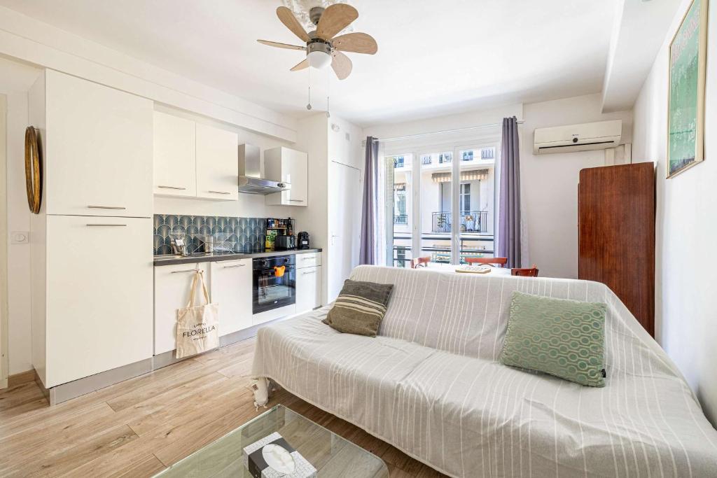 un salon avec un canapé et une cuisine dans l'établissement L'ANGLE DOUX avec balcon idéal pour couples ou en solo, à Cannes