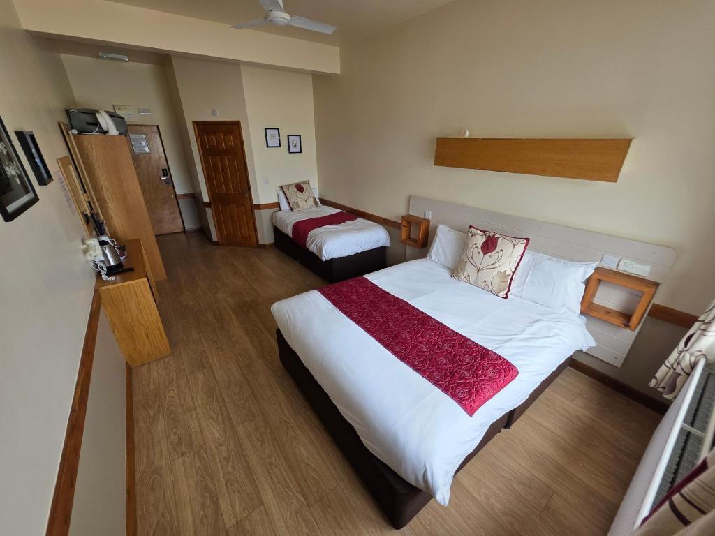 a hotel room with a large bed and a chair at Villager Hotel, Ingoldmells in Ingoldmells