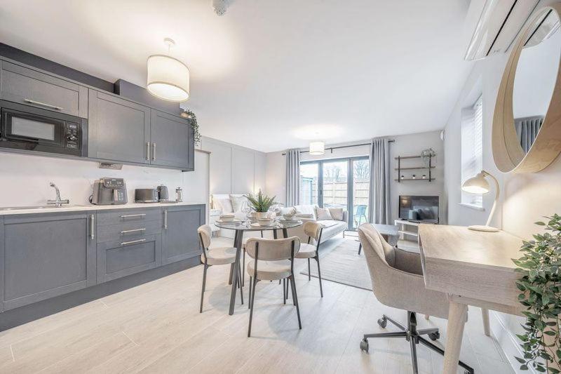 a kitchen and living room with a table and chairs at Silver Birches by MCF in Redhill