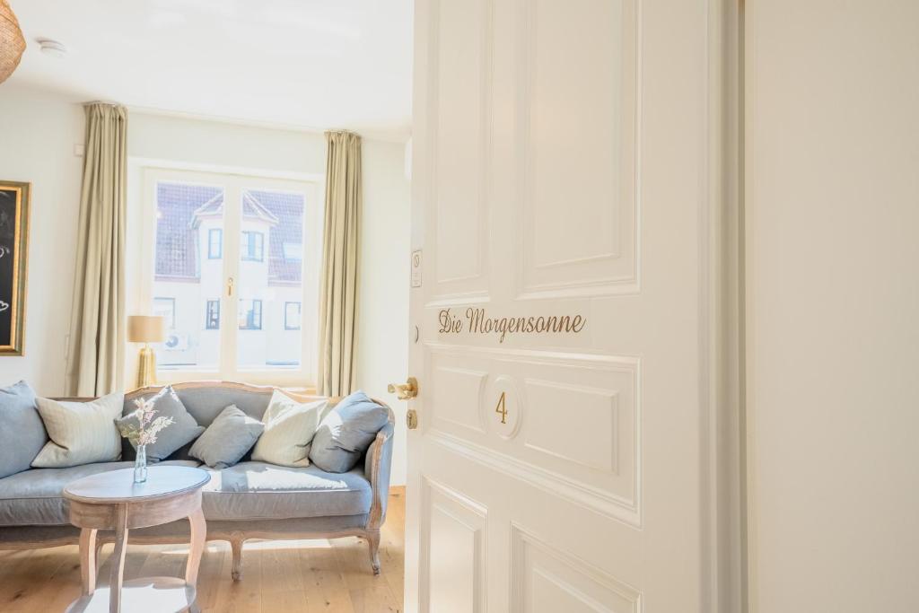 a living room with a couch and a table at SCHLOSSBERG RESIDENCES - Betthupferl - Self Check-In Design Studios Aschaffenburg in Goldbach