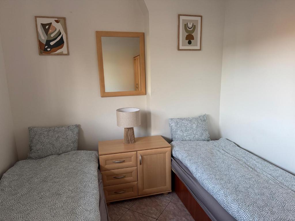a bedroom with two twin beds and a mirror at Apartament Juratka in Jurata