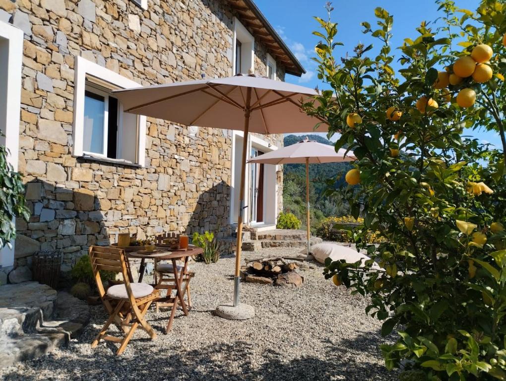 a patio with a table and an umbrella in front of a building at Briciole di Pietra B&B in Dolceacqua