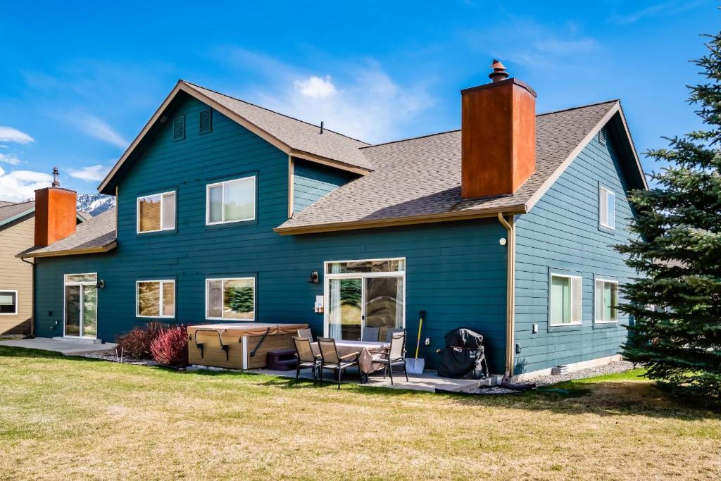 a large blue house with a yard at 3BR Big Sky Getaway with Hot Tub and Mountain Views in Big Sky
