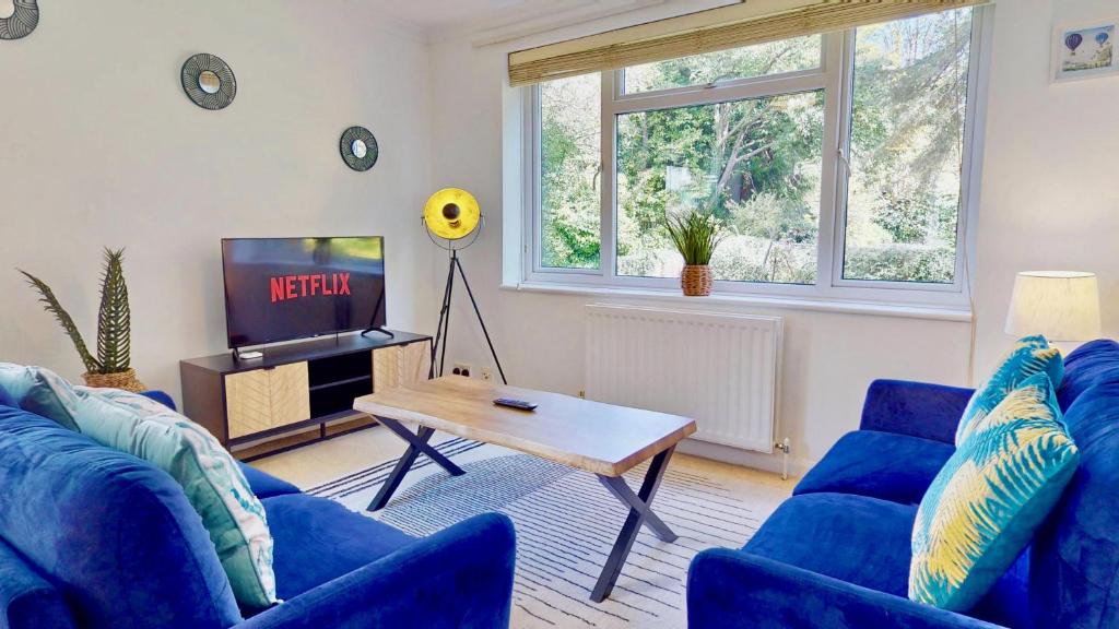 a living room with blue couches and a tv at Rosehill Walk Peaceful Ground Floor Home in Central Tunbridge Wells in Royal Tunbridge Wells