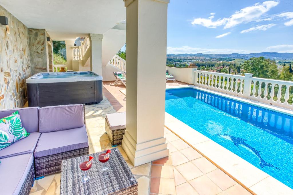 a house with a swimming pool and a purple couch at Casa Lorraine in Mijas