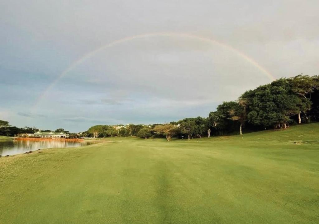 a rainbow over the green at a golf course at Cosy Urban Apartment in Durban