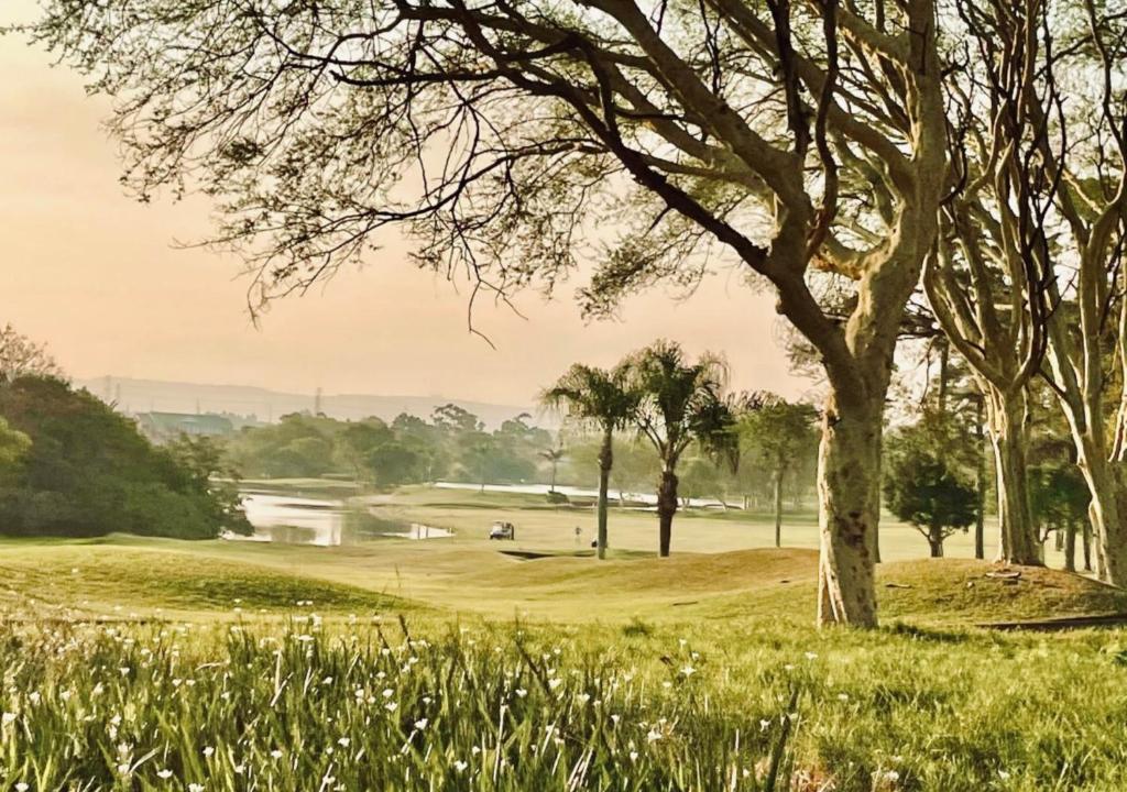 a view of a golf course with a river and trees at Cosy Urban Apartment in Durban