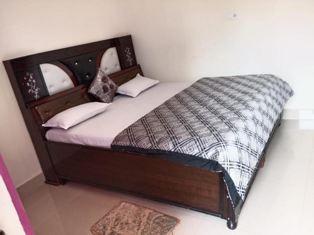 a bedroom with a bed with a wooden frame at Om som home stay hill view in Jāmb