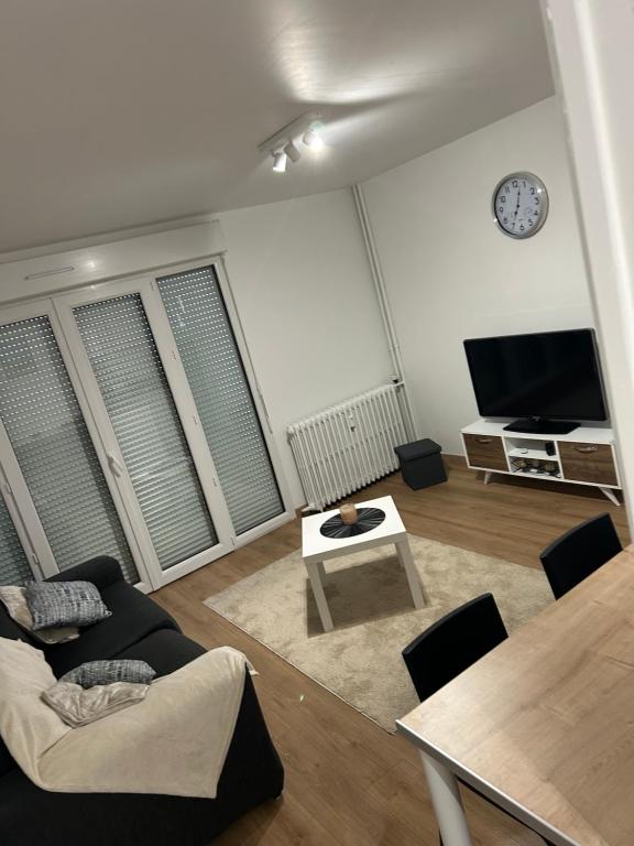 een woonkamer met een bank en een tafel bij Appartement T2 in Dax