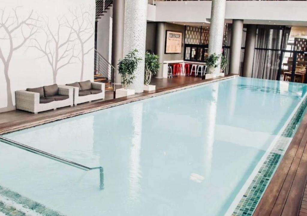 a large swimming pool in a hotel lobby at Cosy Urban Apartment in Durban