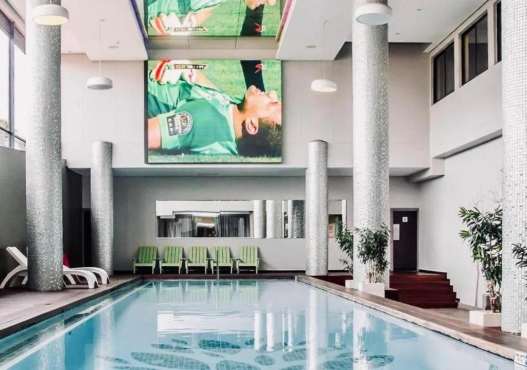 a swimming pool in a hotel with a large painting on the wall at Cosy Urban Apartment in Durban