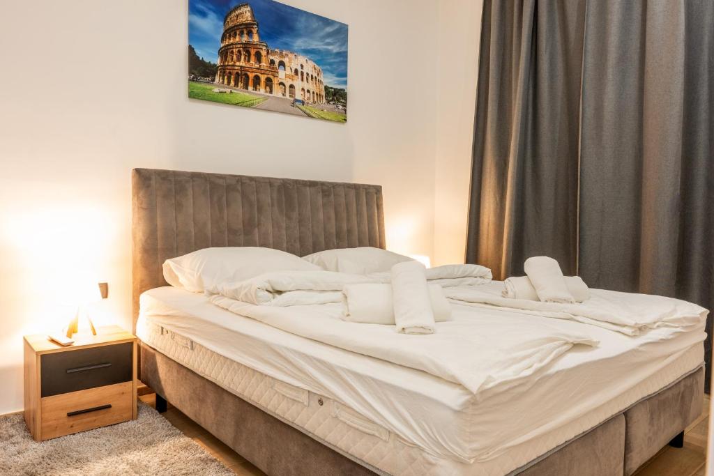 a bed with white sheets and pillows in a bedroom at StayWithUs , ground Floor in Zagreb