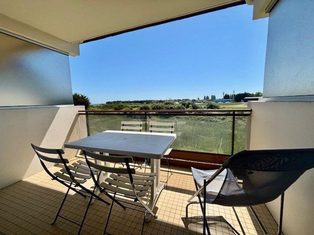 une table et des chaises sur un balcon avec vue dans l'établissement Studio lumineux 27m² à Quiberon, proche mer - FR-1-478-316, à Quiberon