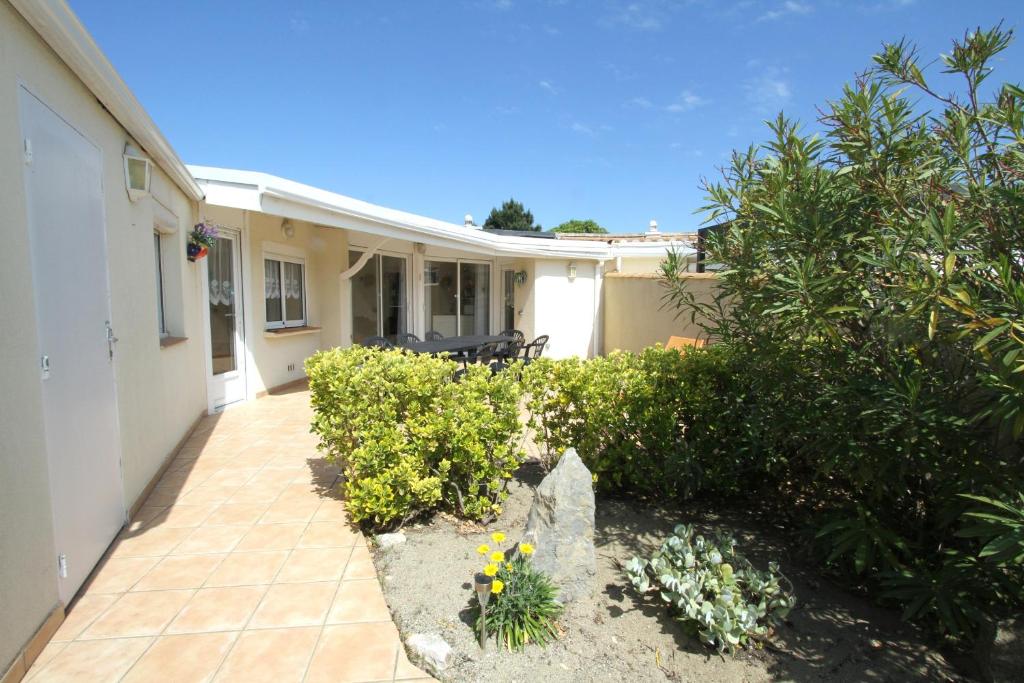 une maison avec une terrasse ornée de plantes et de fleurs dans l'établissement Villa Tao a quelques pas de la plage, à Torreilles