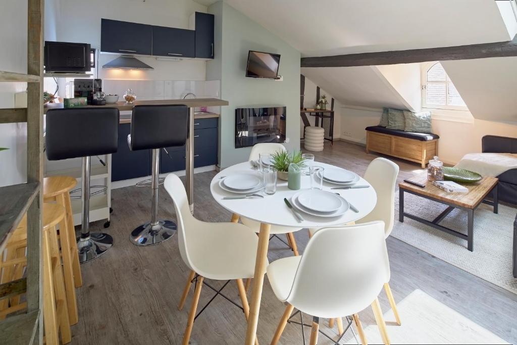 a kitchen and living room with a white table and chairs at Le Nid du Bouffay, Hyper centre de Nantes in Nantes