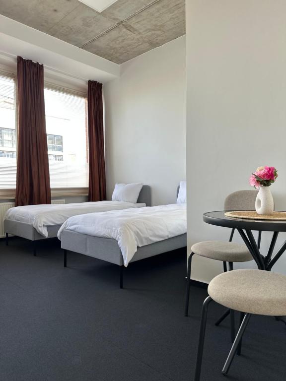 two beds in a room with a table and chairs at 29qm großes Zimmer im Elbvorort in Hamburg