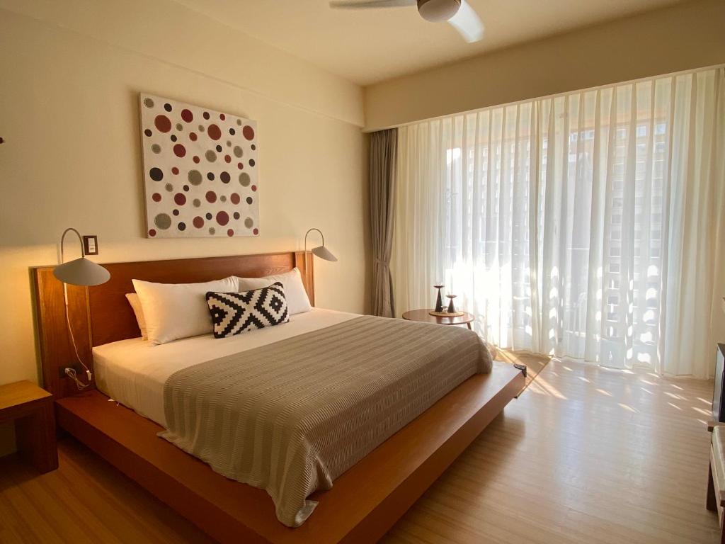 Un dormitorio con una cama y una ventana grande. en The Deer Head Inn, en Kenting