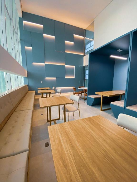 a cafeteria with tables and chairs and blue walls at Fortaleza Sul Flats Service in Fortaleza