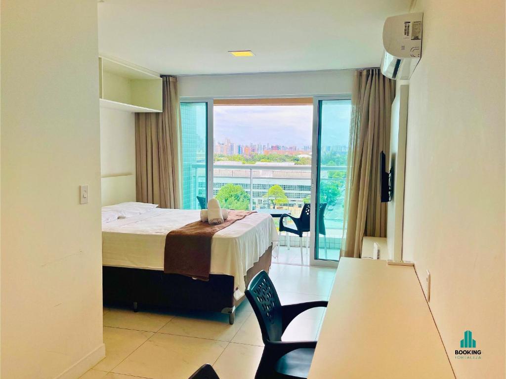 a hotel room with a bed and a large window at Fortaleza Sul Flats Service in Fortaleza