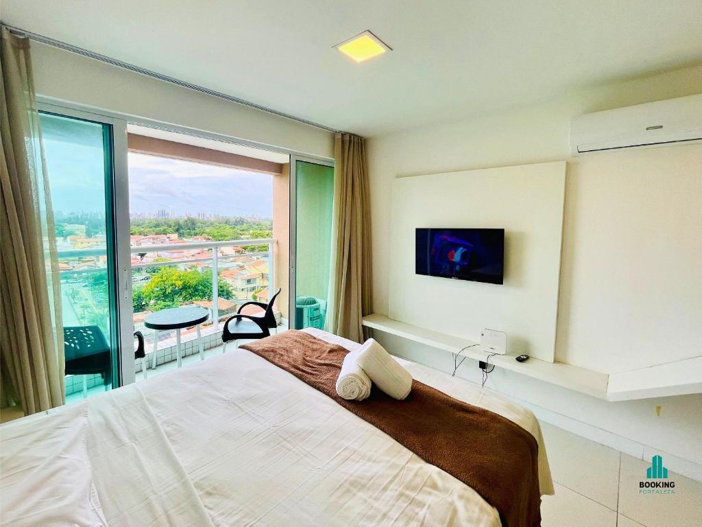a bedroom with a large bed and a large window at Fortaleza Sul Flats Service in Fortaleza