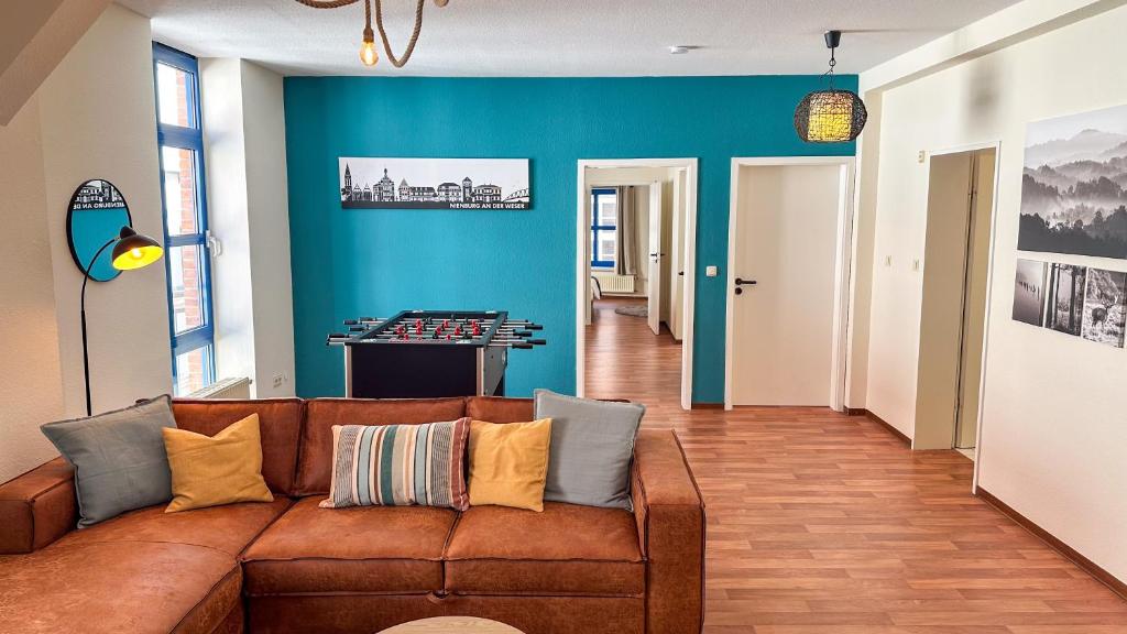 a living room with a brown couch and a blue wall at MaBu Homes - Mitten in Nienburg in Nienburg