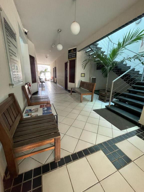 a lobby with benches and stairs in a building at Pousada Maria Bonita - Centro, 10min da Praia de Camapum, Macau RN in Macau