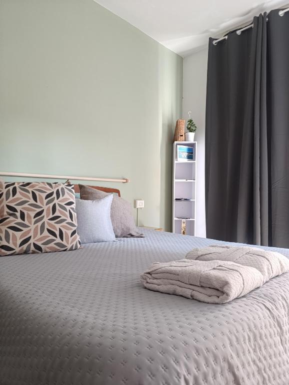 una camera da letto con un grande letto con una tenda grigia di Loano Experience - 70m dal mare a Loano