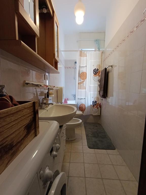 un piccolo bagno con lavandino e WC di Loano Experience - 70m dal mare a Loano