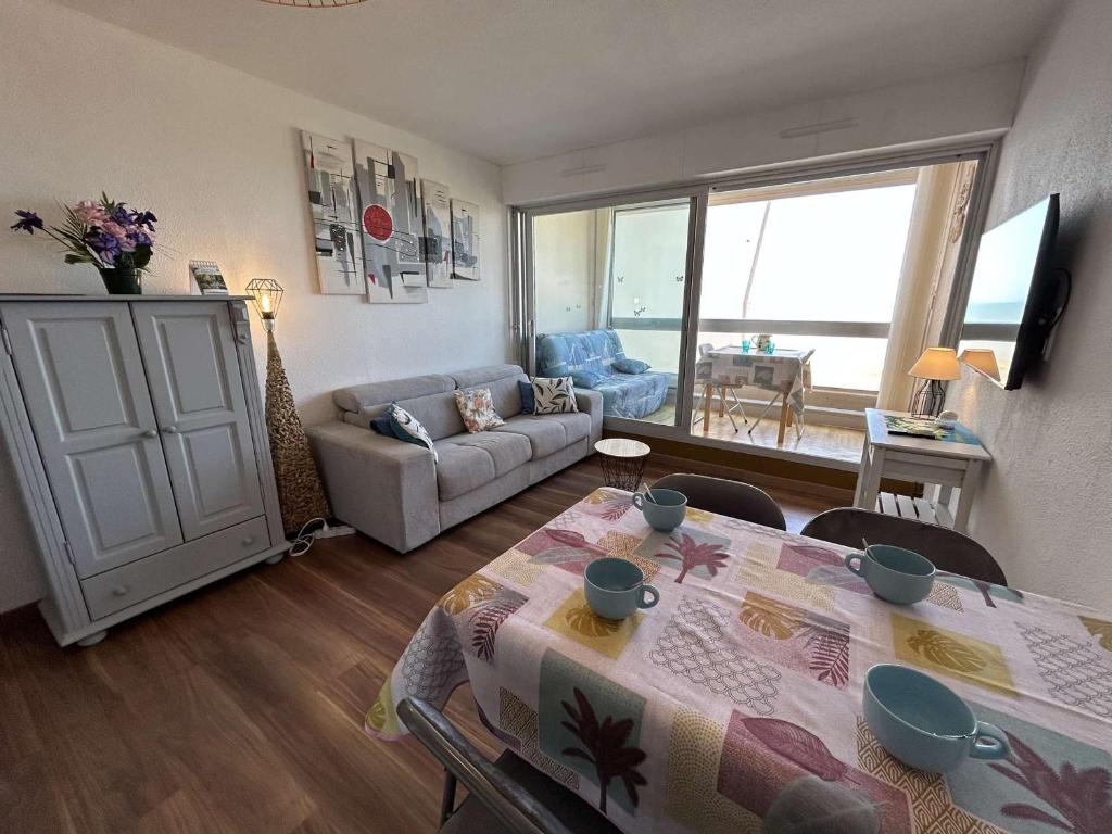 un salon avec une table et un canapé dans l'établissement Studio cabine à 20m de la plage avec parking privé - FR-1-224C-325, à Saint-Jean-de-Monts