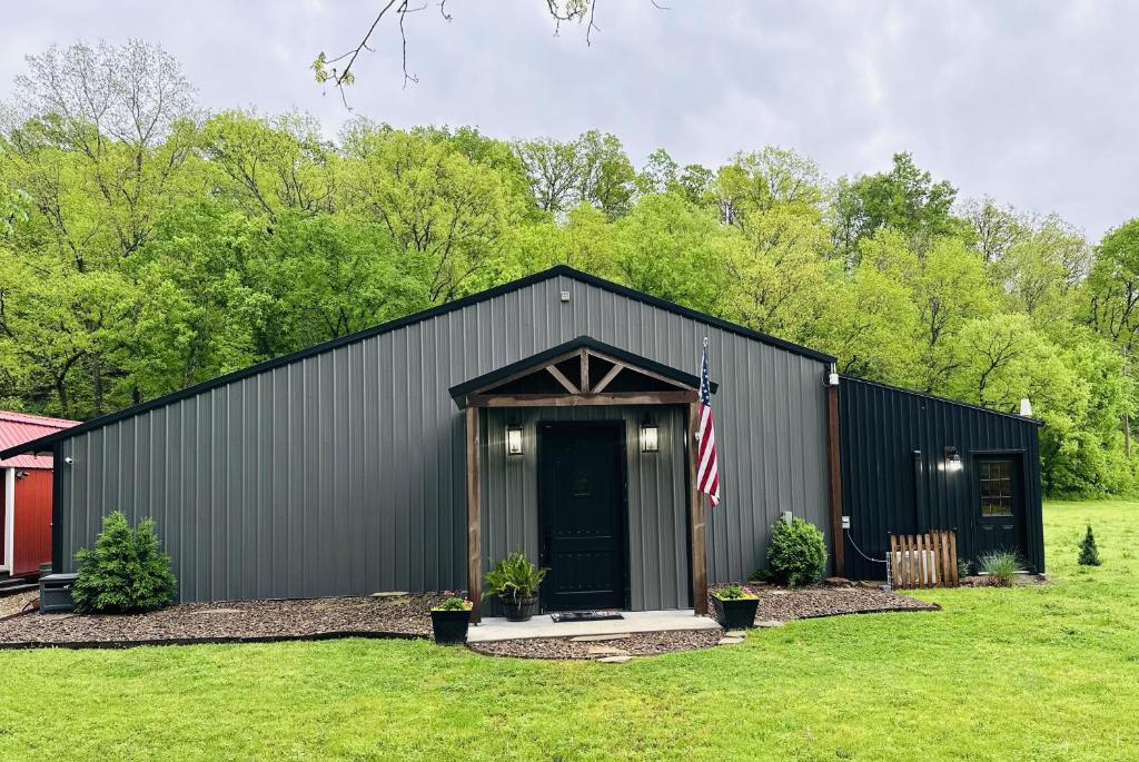 a black building with a flag on it at Legacy Barn on Sugar Creek in Bentonville