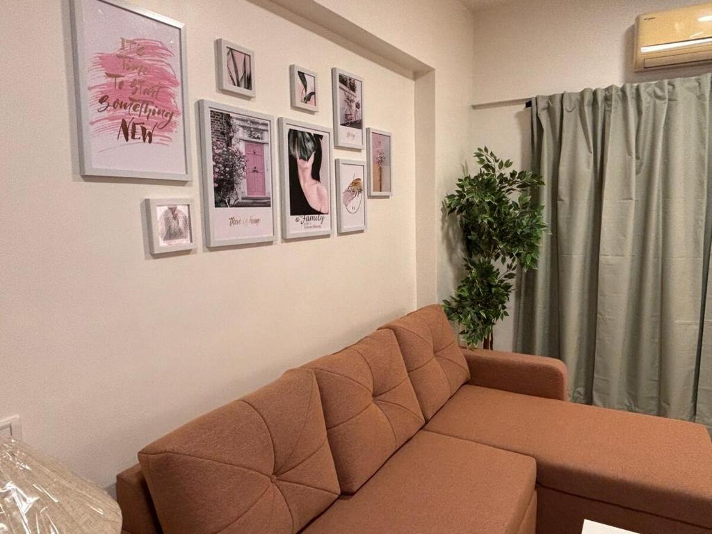 un soggiorno con divano e immagini appese al muro di Spacious 1BHK Off Carter Road a Mumbai