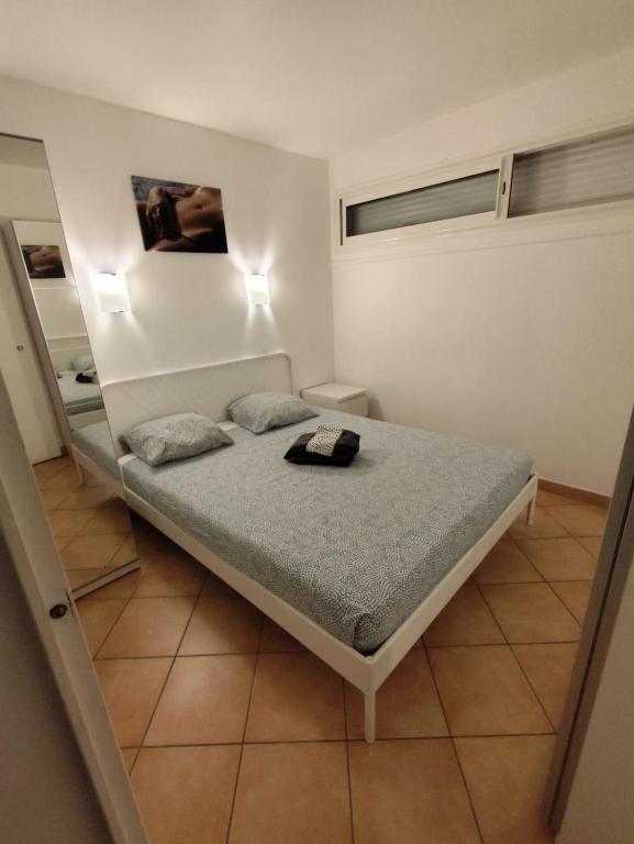 une chambre avec un lit dans une pièce avec deux fenêtres dans l'établissement Naturiste Cap d'Agde Port Ambonne 239, au Cap d'Agde