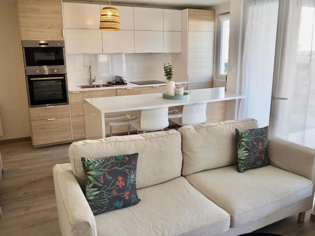 a living room with a couch and a kitchen at Appart T2 cabine 5 min du centre in Le Touquet-Paris-Plage