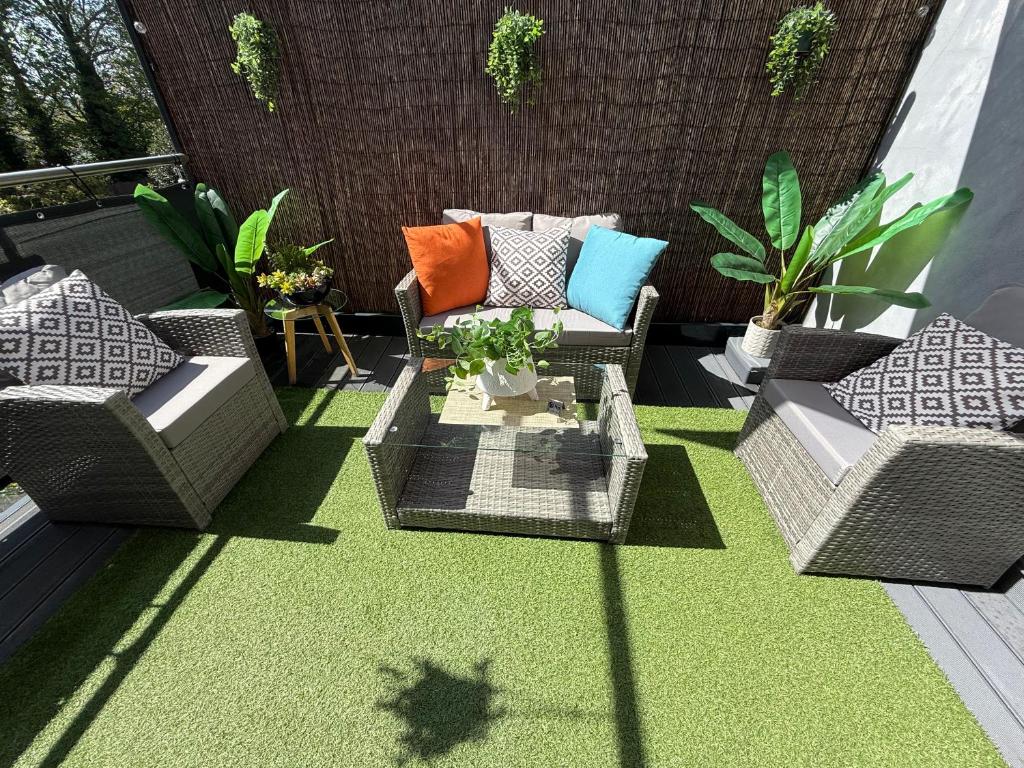a patio with two wicker chairs and a table at The Duplex Margate with Deck & Living Space Air Conditioning in Margate