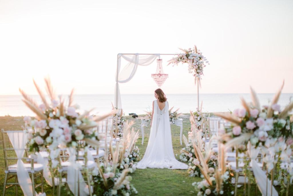 a bride walking down the aisle at a wedding with flowers at InterContinental Bali Resort by IHG in Jimbaran