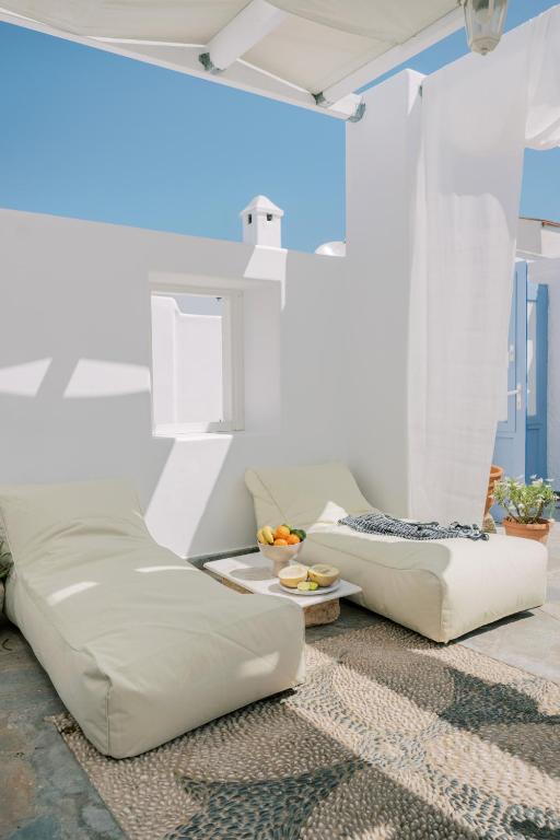 a living room with two white couches and a table at Aegean Nest in Koskinou